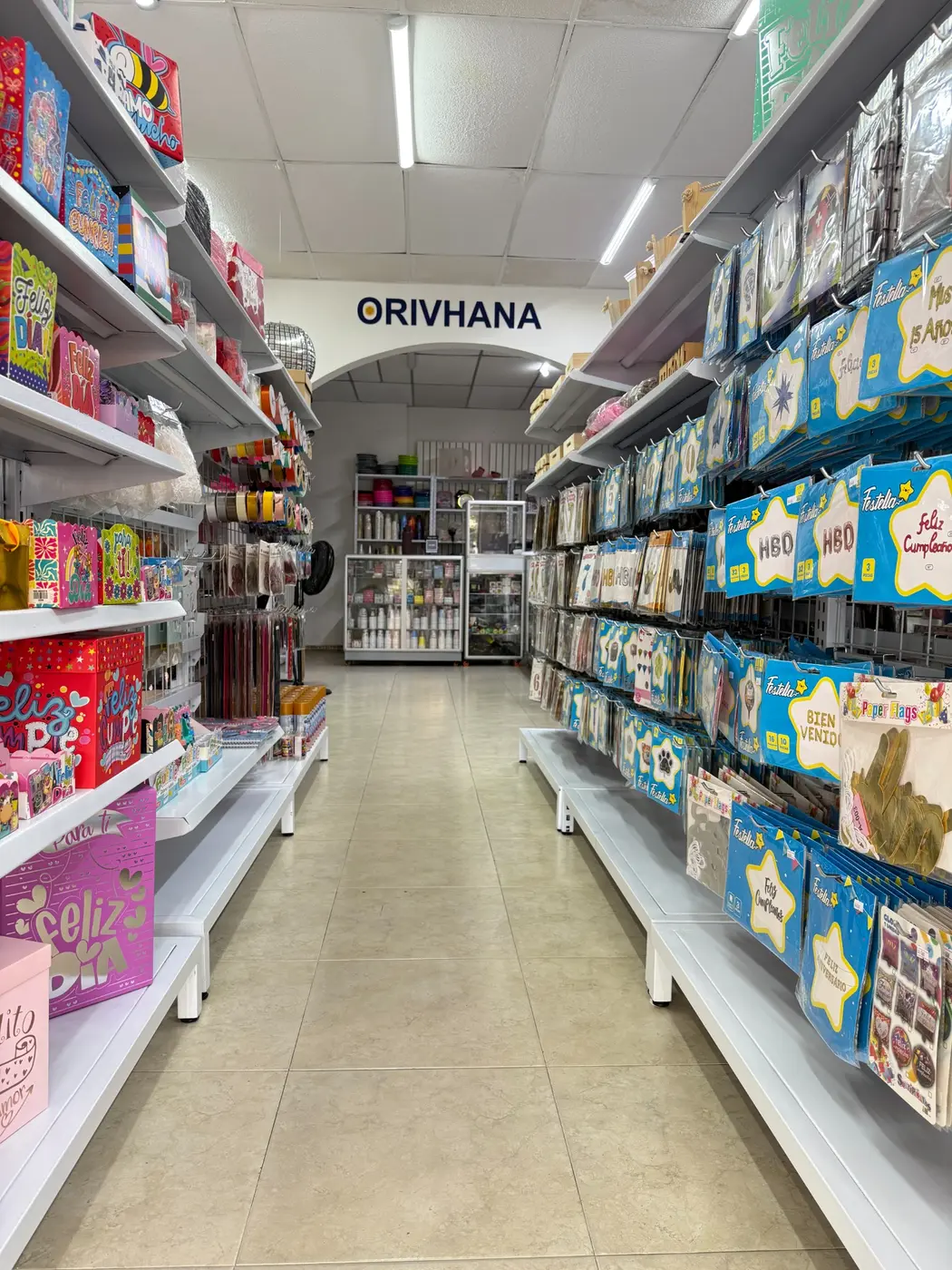 Pasillo principal del almacén Orivhana con productos para celebraciones