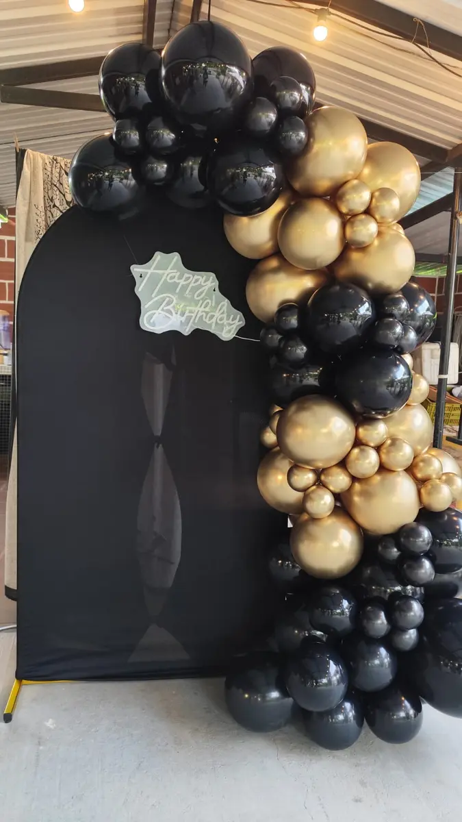 Decoración de cumpleaños en negro y dorado realizada por Orivhana